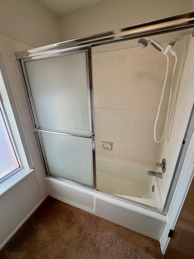 bathroom featuring bath / shower combo with glass door