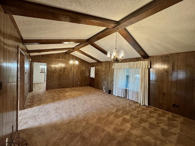 bonus room with lofted ceiling with beams, an inviting chandelier, and wood walls