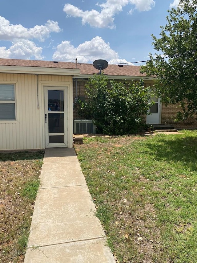 doorway to property with a lawn