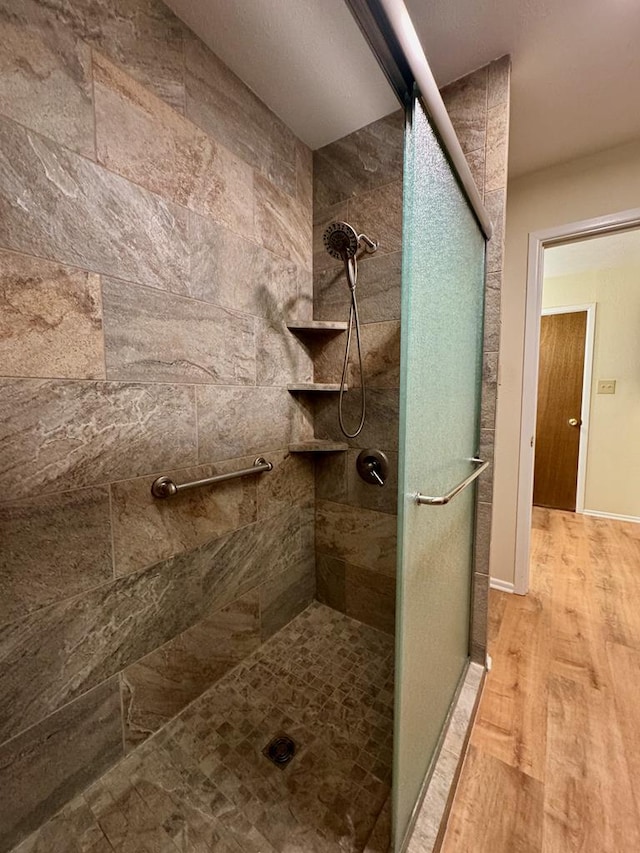 bathroom featuring hardwood / wood-style flooring and a shower with door