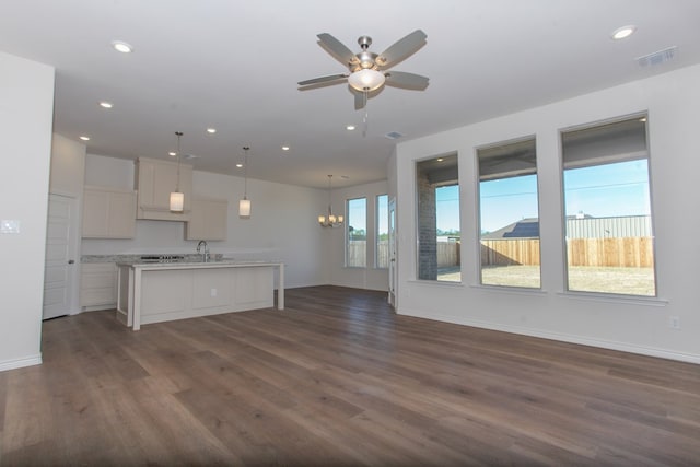 unfurnished living room with sink, dark hardwood / wood-style flooring, and ceiling fan with notable chandelier