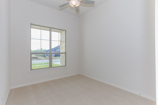 spare room featuring light colored carpet and ceiling fan