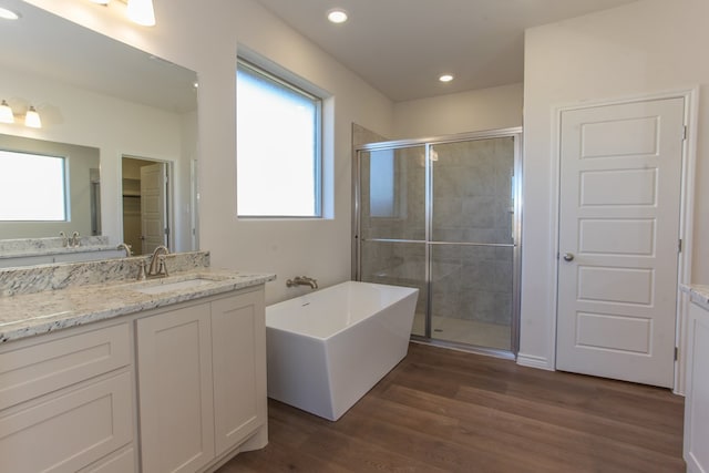 bathroom featuring hardwood / wood-style flooring, vanity, and separate shower and tub