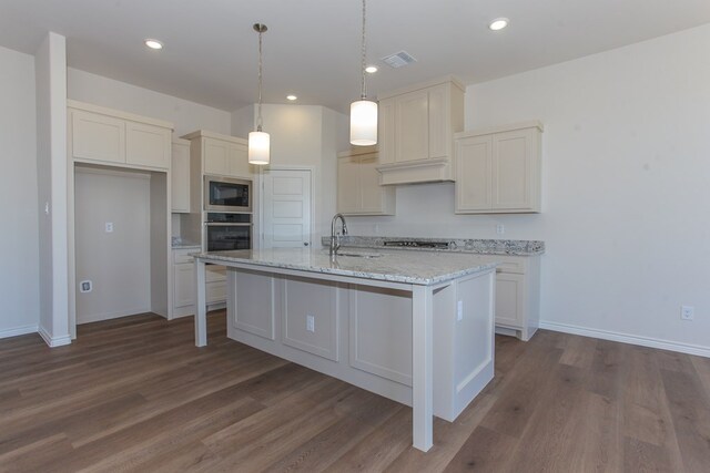 kitchen featuring sink, appliances with stainless steel finishes, a kitchen island with sink, dark hardwood / wood-style floors, and decorative light fixtures