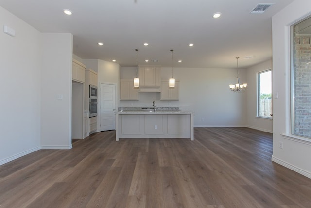 kitchen featuring sink, decorative light fixtures, stainless steel appliances, and a center island with sink