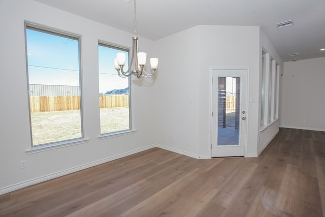 unfurnished dining area featuring hardwood / wood-style flooring and a chandelier