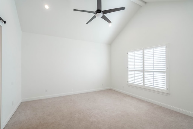 empty room featuring light carpet, ceiling fan, beam ceiling, a barn door, and high vaulted ceiling