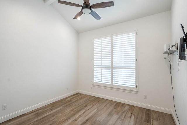 empty room with ceiling fan, light wood-type flooring, and vaulted ceiling