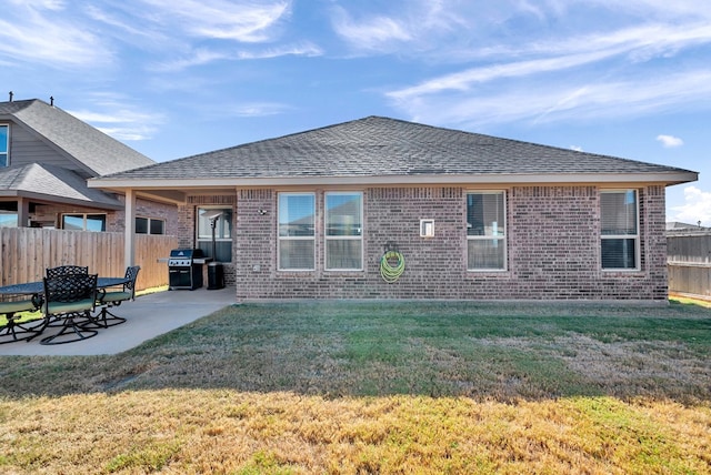 rear view of house with a lawn and a patio area