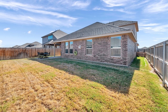 rear view of property with a yard