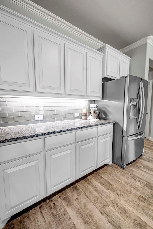 kitchen featuring white cabinetry, stainless steel fridge, tasteful backsplash, and light wood-type flooring