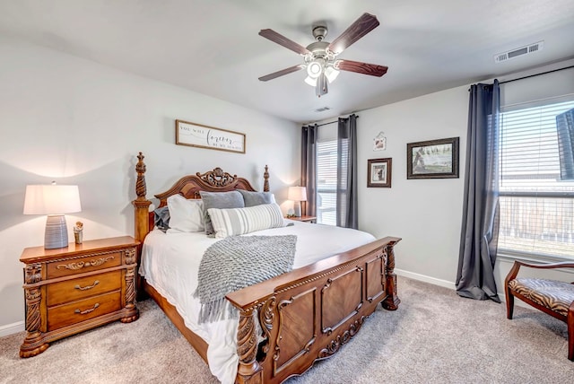 carpeted bedroom with multiple windows and ceiling fan