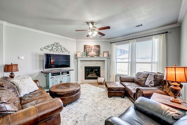 living room featuring crown molding, ceiling fan, and a textured ceiling