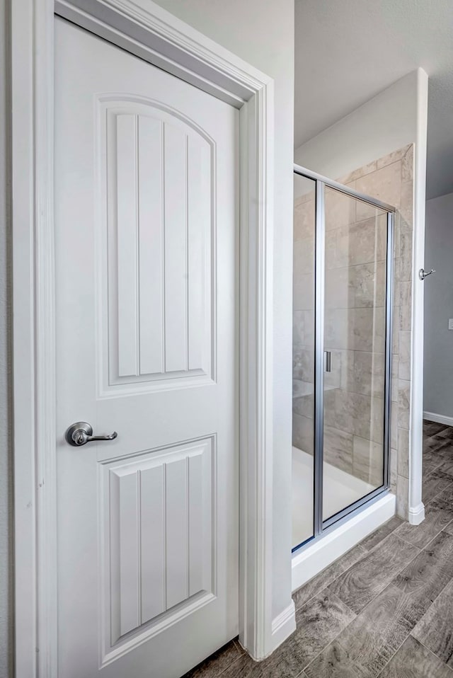 bathroom featuring wood-type flooring and walk in shower