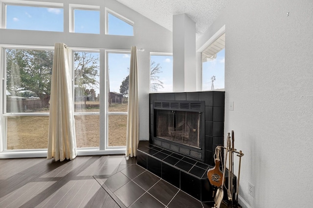 4715 N County Rd 1125, Midland, TX 79705 - detailed view of a textured wall, a textured ceiling, a tiled fireplace, and wood finished floors