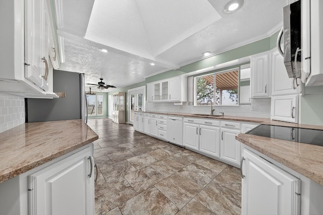 4715 N County Rd 1125, Midland, TX 79705 - kitchen with dishwasher, a textured ceiling, stainless steel microwave, tasteful backsplash, and white cabinetry
