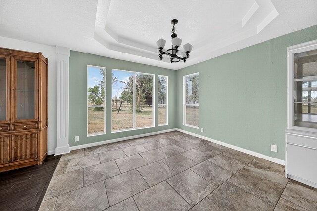 4715 N County Rd 1125, Midland, TX 79705 - unfurnished dining area featuring a tray ceiling, a chandelier, and a textured ceiling