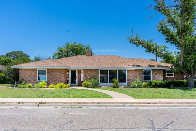 607 N Rio St, Fort Stockton, TX 79735 - ranch-style home featuring a front lawn, a chimney, and brick siding