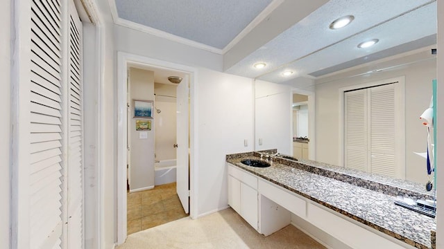 bathroom featuring ornamental molding, vanity, and a textured ceiling