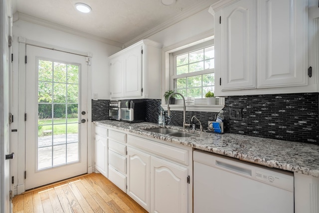 1703 Laurel Ave, Odessa, TX 79761 - kitchen featuring white dishwasher, light wood-type flooring, crown molding, decorative backsplash, and light stone counters