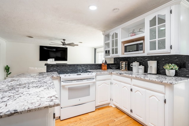 1703 Laurel Ave, Odessa, TX 79761 - kitchen featuring white range with electric cooktop, built in microwave, decorative backsplash, and a ceiling fan