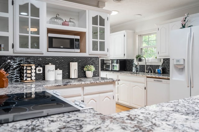 1703 Laurel Ave, Odessa, TX 79761 - kitchen with white appliances, crown molding, glass insert cabinets, light stone countertops, and backsplash