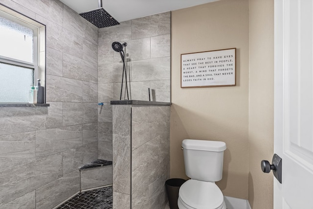 bathroom featuring a tile shower and toilet