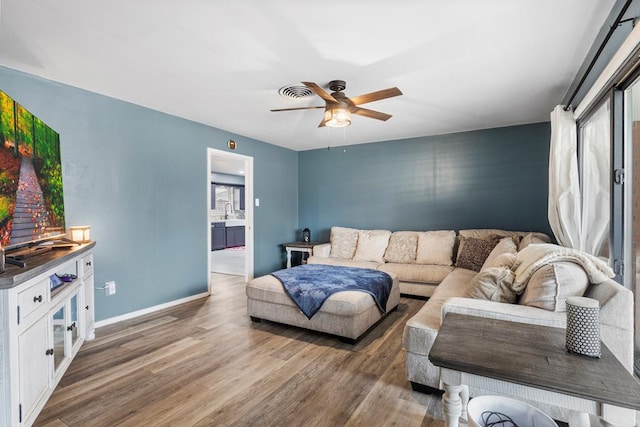 living room featuring hardwood / wood-style floors, sink, and ceiling fan