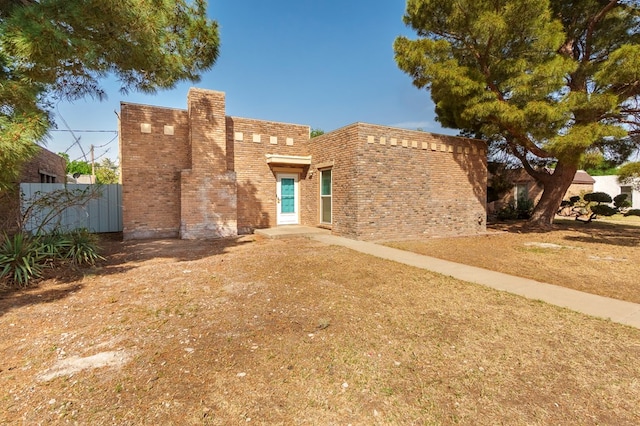 southwest-style home with brick siding and fence