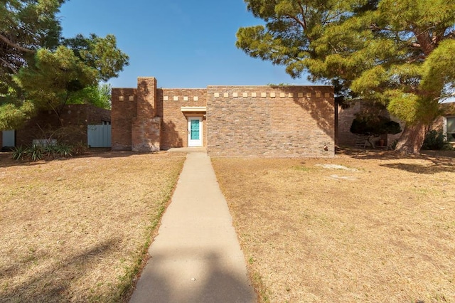 pueblo revival-style home featuring brick siding