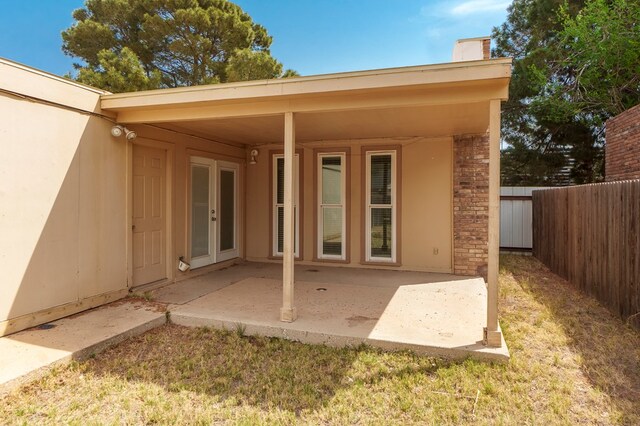 rear view of property with a patio area, stucco siding, stone siding, and fence