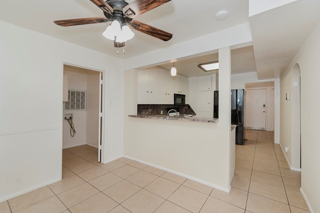 kitchen with ceiling fan, white cabinetry, black appliances, light tile patterned flooring, and backsplash
