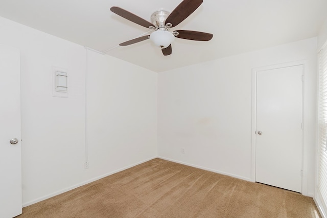 empty room with baseboards, light colored carpet, and a ceiling fan