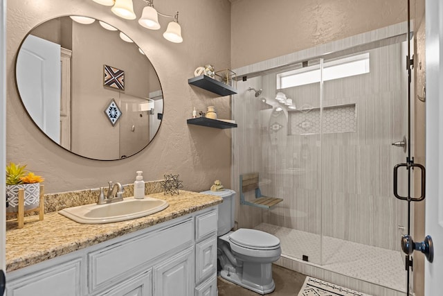 bathroom with a shower with door, vanity, and toilet