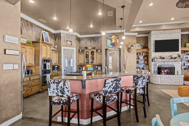 kitchen featuring pendant lighting, crown molding, dark stone counters, and a kitchen bar