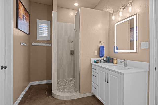 bathroom featuring tile patterned flooring, vanity, and walk in shower