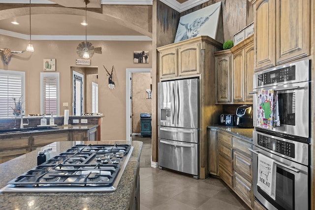 kitchen with tile patterned floors, sink, crown molding, appliances with stainless steel finishes, and pendant lighting