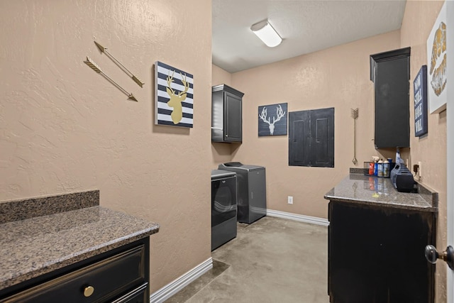 laundry room with cabinets, washer and dryer, and a textured ceiling