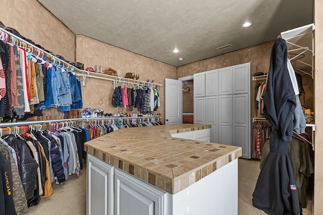 spacious closet featuring light colored carpet