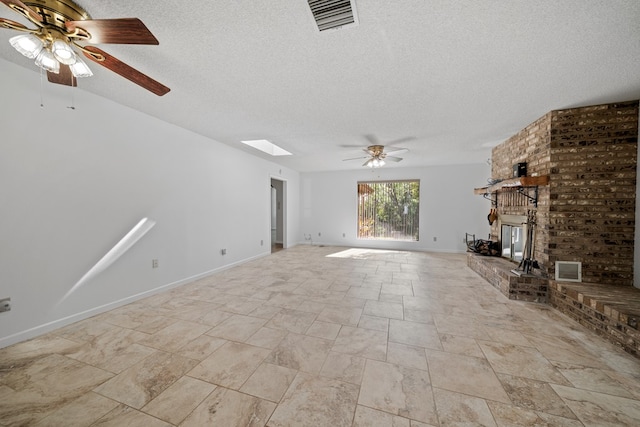2100 Edgemere Rd, Big Spring, TX 79720 - unfurnished living room featuring ceiling fan, a textured ceiling, a skylight, a brick fireplace, and light stone finish flooring