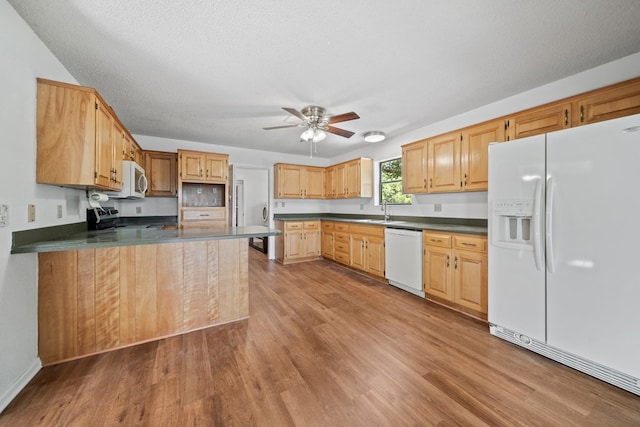 2100 Edgemere Rd, Big Spring, TX 79720 - kitchen with white appliances, wood finished floors, dark countertops, ceiling fan, and a textured ceiling