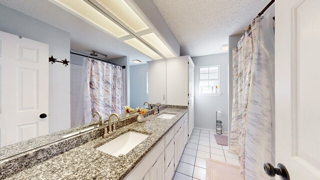 bathroom featuring tile patterned floors, vanity, and a textured ceiling