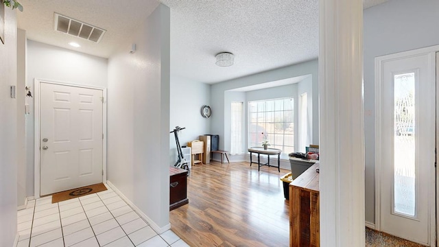 entryway featuring a textured ceiling and light hardwood / wood-style floors