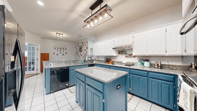 kitchen with appliances with stainless steel finishes, blue cabinetry, light tile patterned floors, white cabinets, and a kitchen island