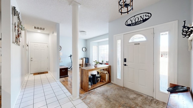 entryway with light tile patterned flooring and a textured ceiling