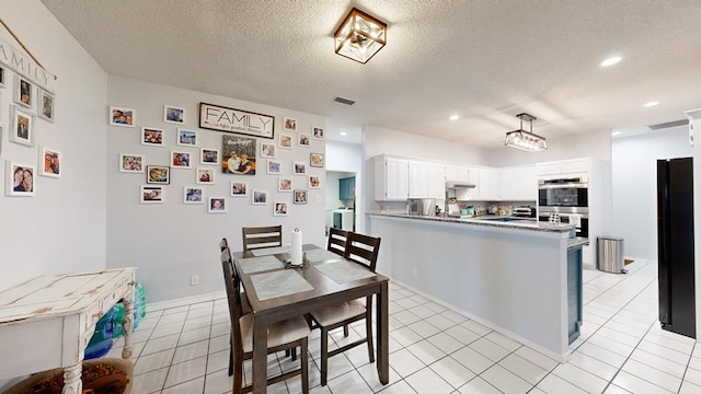 kitchen featuring kitchen peninsula, white cabinets, stainless steel double oven, and light tile patterned floors