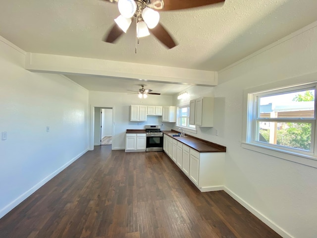 3007 S Anderson Rd, Big Spring, TX 79720 - kitchen featuring stainless steel range with gas stovetop, dark wood finished floors, a ceiling fan, and white cabinets