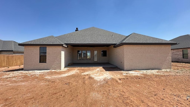 2118 S County Rd 1059, Midland, TX 79706 - back of house with brick siding, fence, a patio area, and roof with shingles
