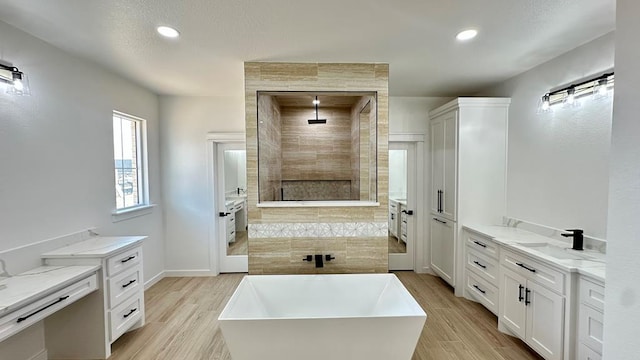 2118 S County Rd 1059, Midland, TX 79706 - bathroom with walk in shower, a soaking tub, wood finished floors, vanity, and recessed lighting