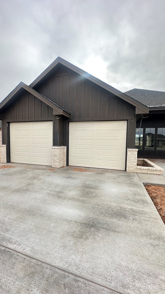 view of front of property with an attached garage, concrete driveway, and board and batten siding